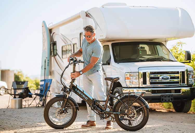 Person with electric bike in front of an RV