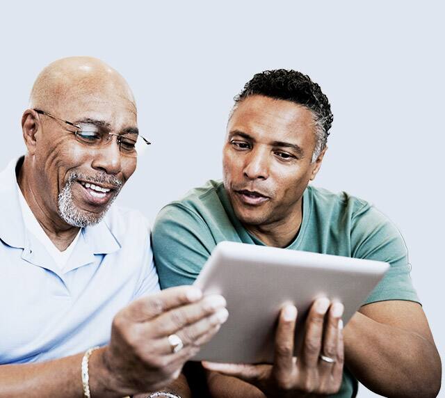Two men looking at tablet.