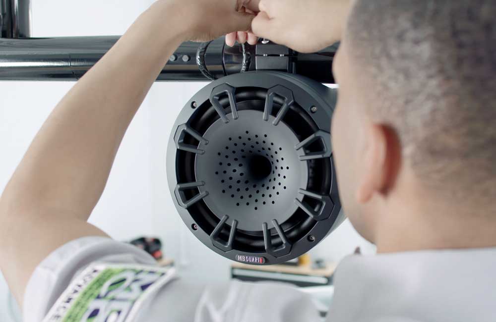 Geek Squad agent installing speaker in boat.