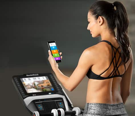 Woman on studio cycle with smartphone
