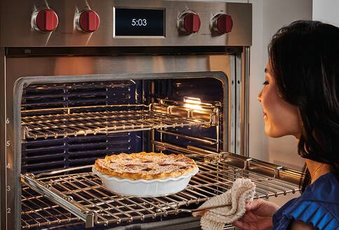 Person looking at pie in oven