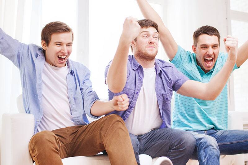 People sitting on a couch and cheering