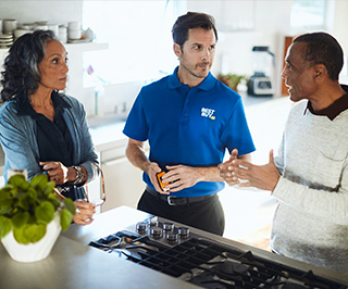 Best Buy Home Expert helps two customers with a gas oven range.