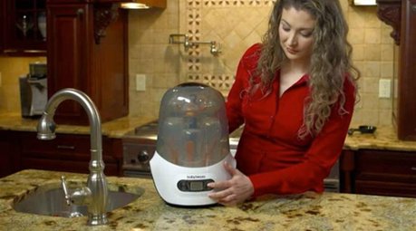 Woman with baby bottle sterilizer
