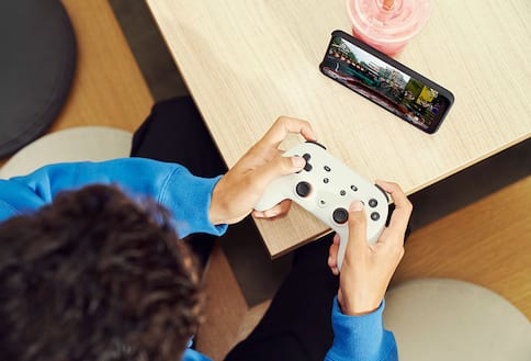 Person using gaming controller with game on cell phone