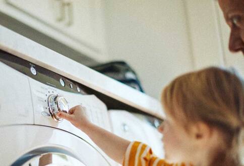 Kid and parent at washing machine