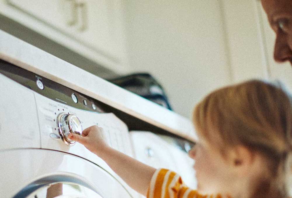 Kid and parent at washing machine