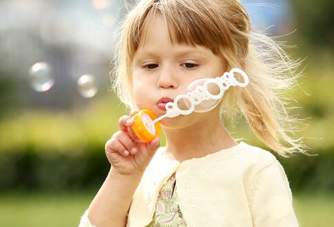 litte girl blowing bubbles