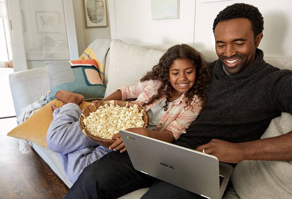 Dad and daughter on couch with Chromebook