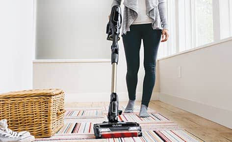 Person vacuuming a rug