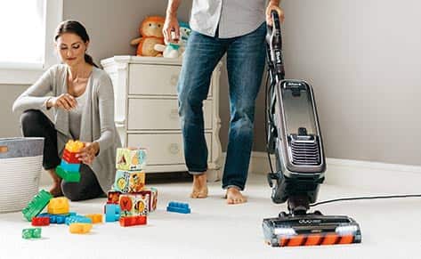 Person vacuuming carpet.