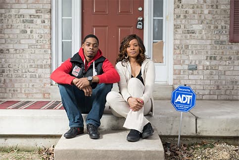 Couple in front of home with ADT sign