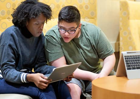 Girl and boy looking at laptop