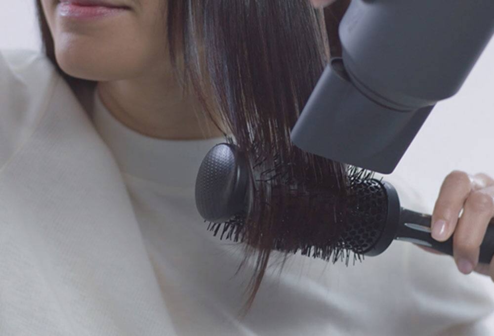 Person using round brush and nozzle