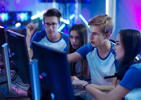 Four students looking at computer monitors