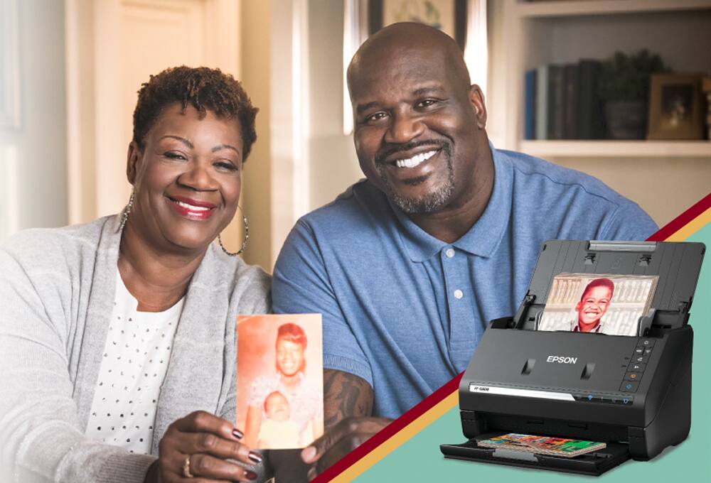 Mother and son holding family photos, photo scanner