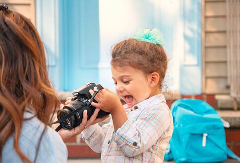 Girl looking at pictures in camera viewfinder