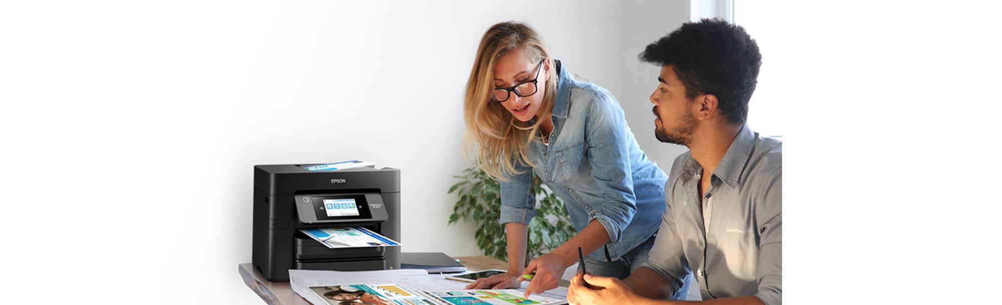 Two people reviewing documents from a printer