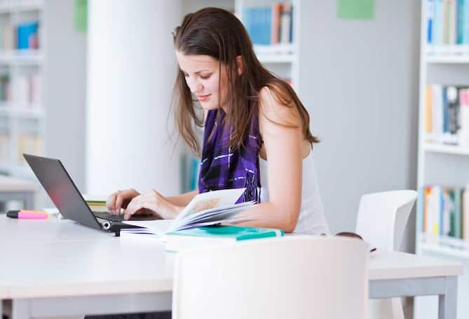Young woman sitting at desk with laptop