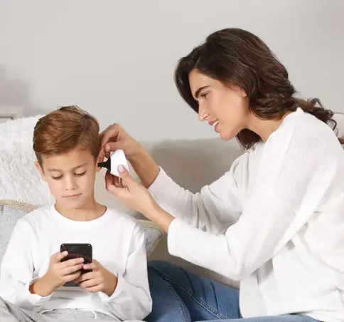 Mom and child using ear exam device