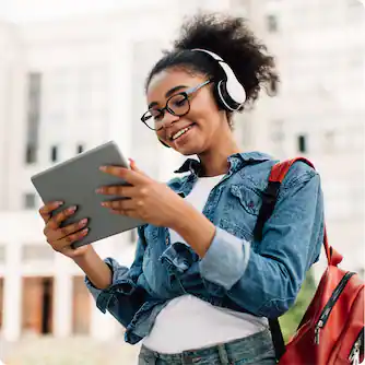 Teen girl wearing headphones and using tablet