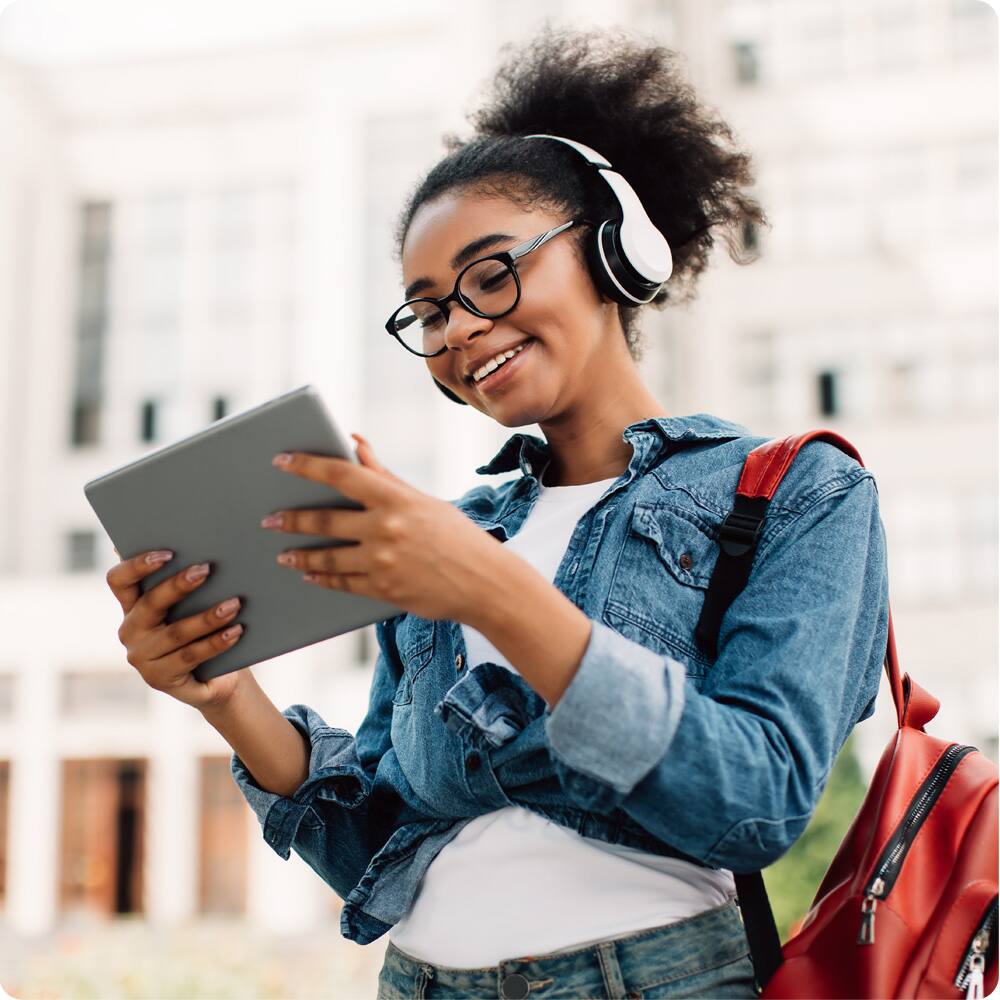 Teen girl wearing headphones and using tablet