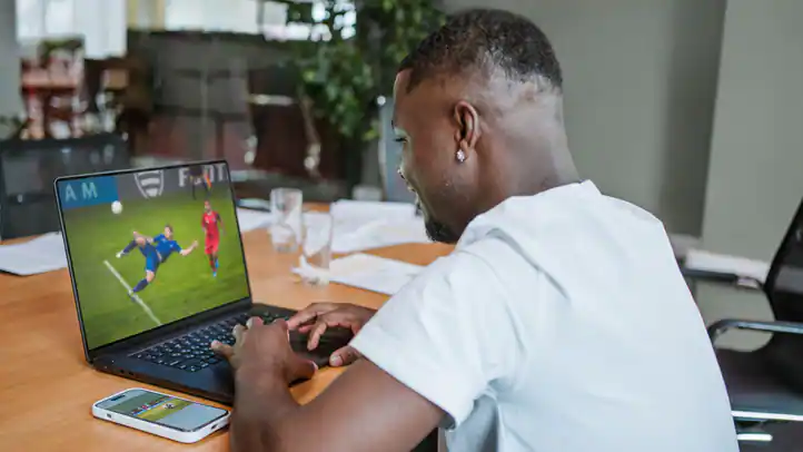 Man watching soccer on laptop
