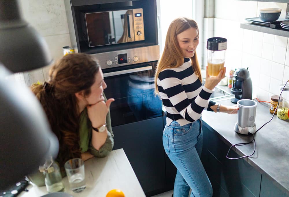 Two women make a smoothie