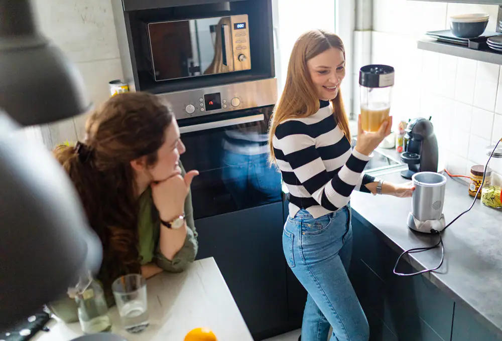 Two women make a smoothie