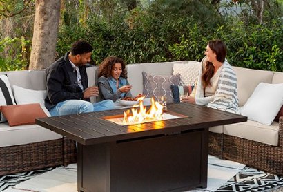 People seated on patio furniture in front of fire table