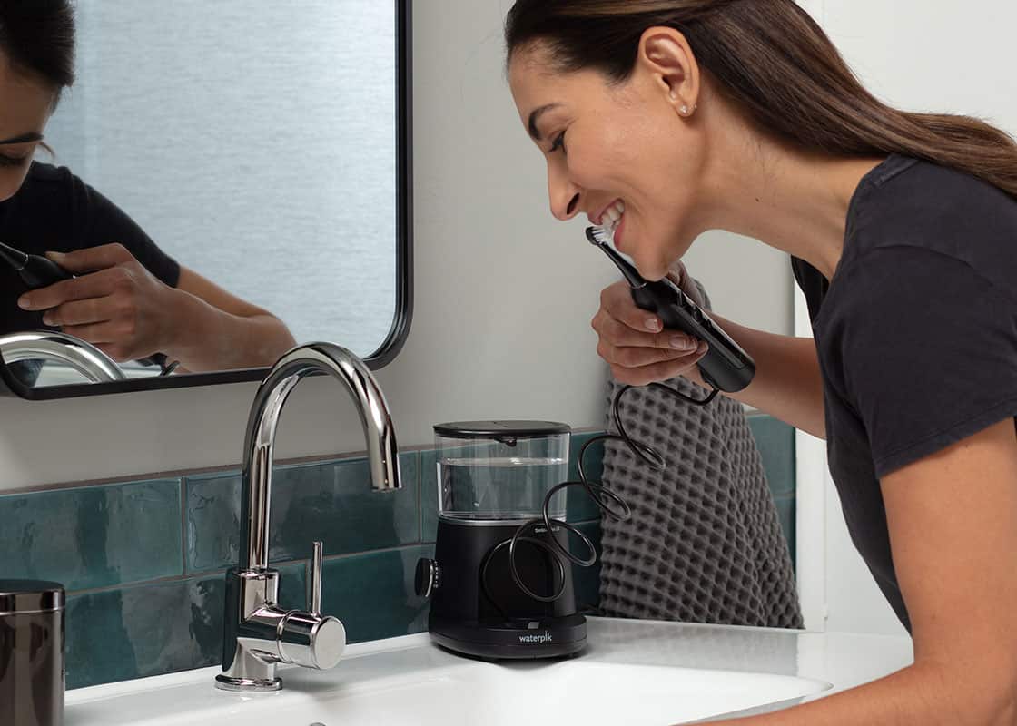 Person brushing their teeth with Waterpik Sonic-Fusion 2.0.