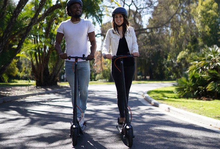 Man and woman riding electric scooters