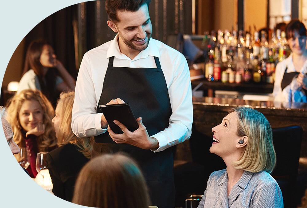 Person in busy restaurant wearing earbuds