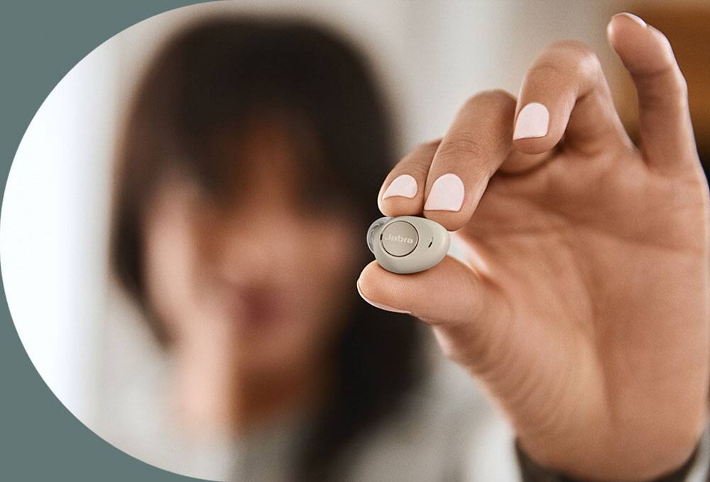 Person holding small earbuds