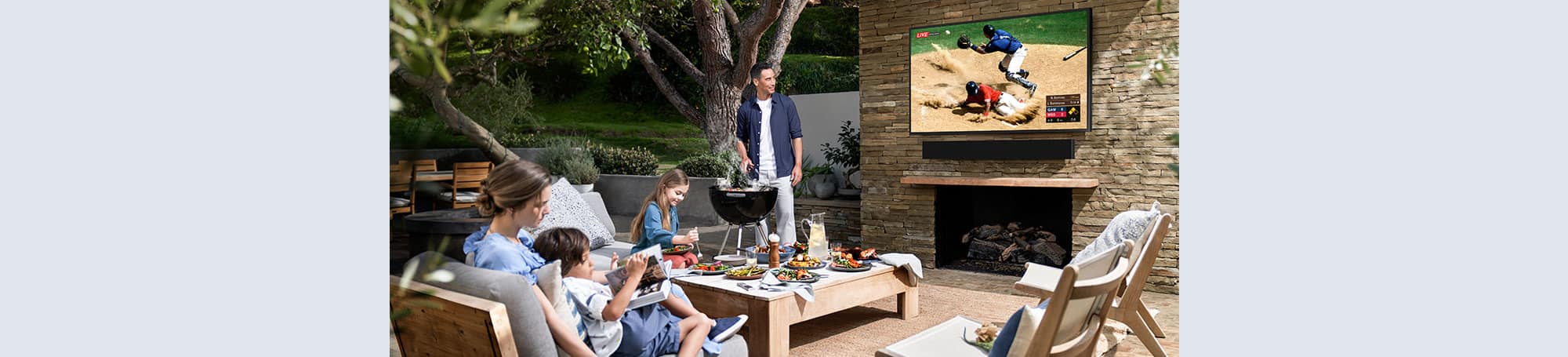 Family on patio, grilling and watching TV