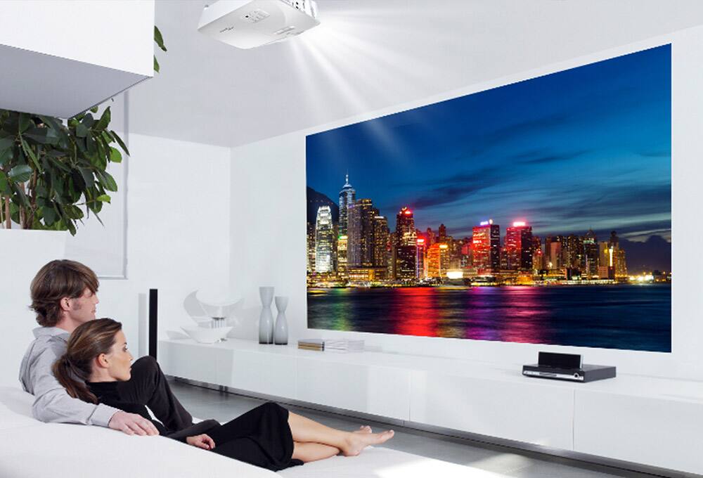 People on couch, watching a projection screen