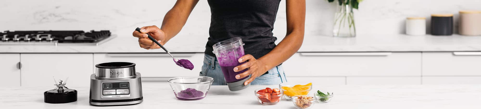 Person transferring blended food from blender cup to bowl