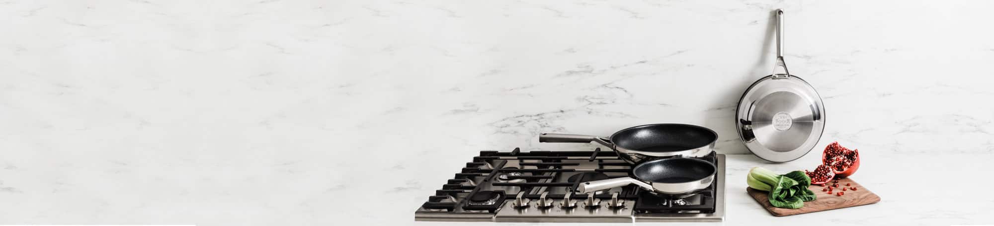 Stainless cookware on stove top and countertop