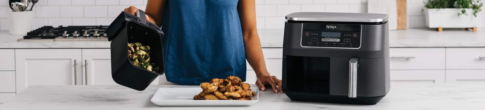 Person emptying food from air fryer basket onto platter