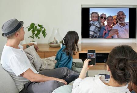 Person displaying a photo from a phone to a TV