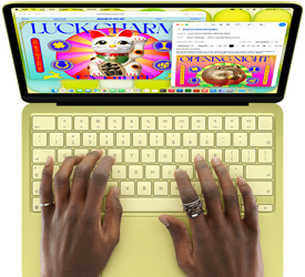 MacBook Neo, citrus color, hands on keyboard, user is composing an email invitation to the opening of an art exhibit, website for the event open alongside