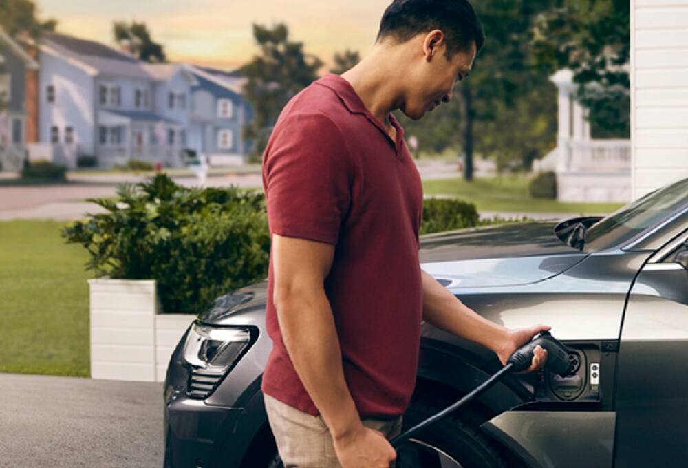 Man plugging in his electric vehicle (EV)