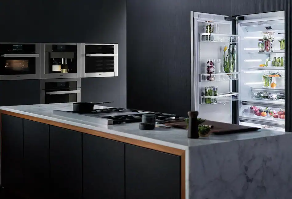 Dark gray kitchen with built-in appliances, cooktop on island, open fridge
