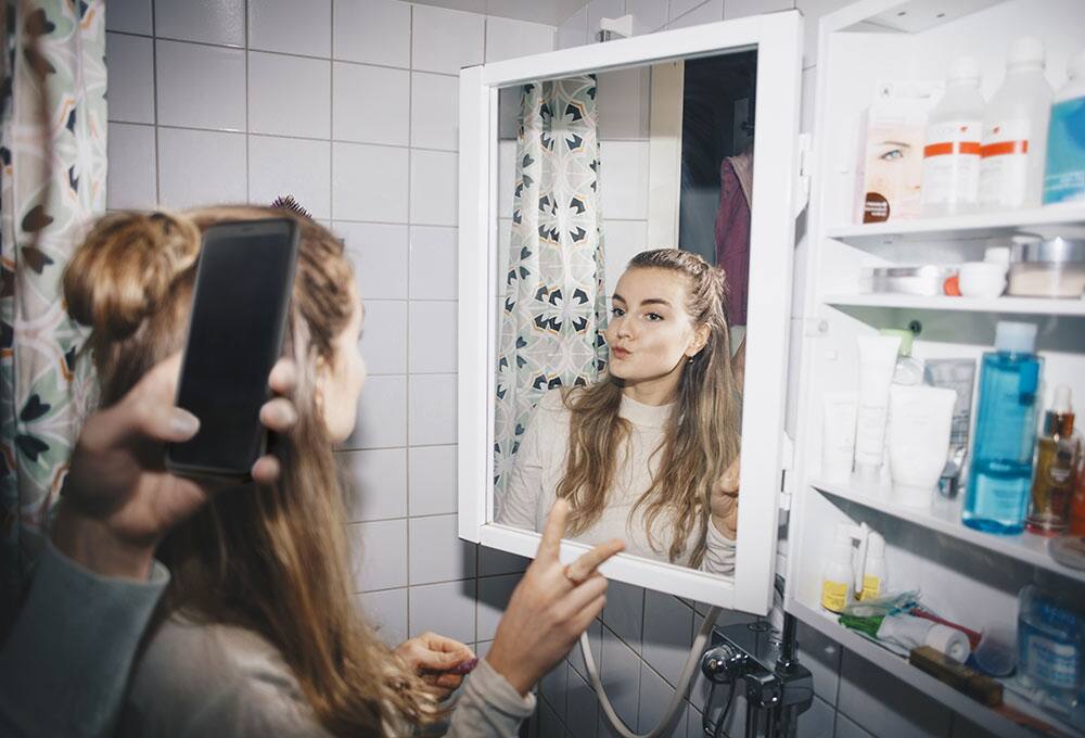 College student taking selfie in a mirror
