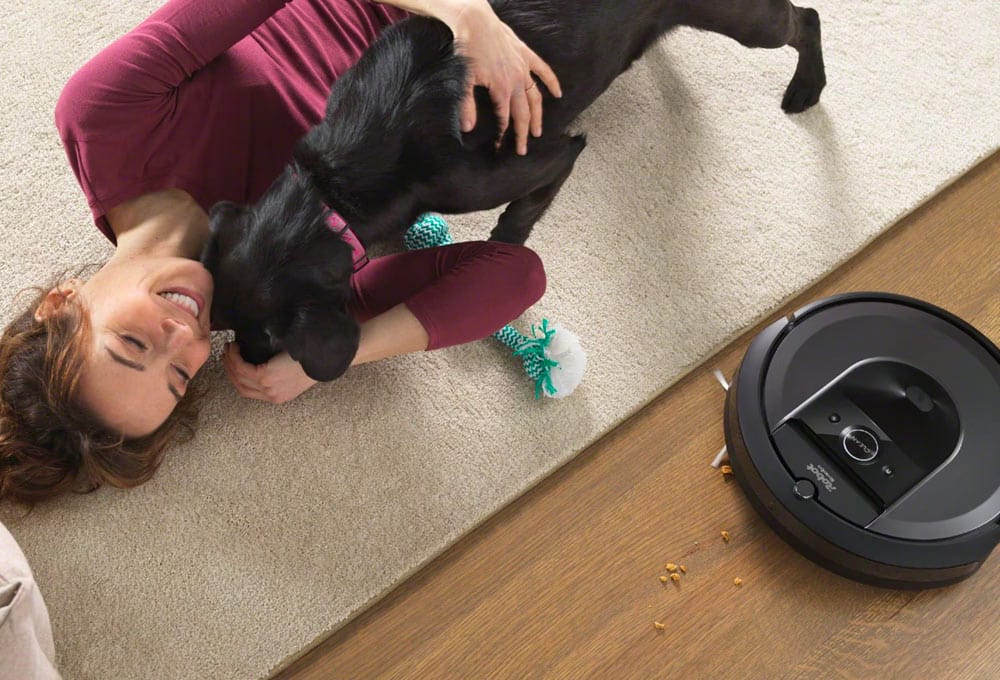Robot vacuum in living room with dog and person