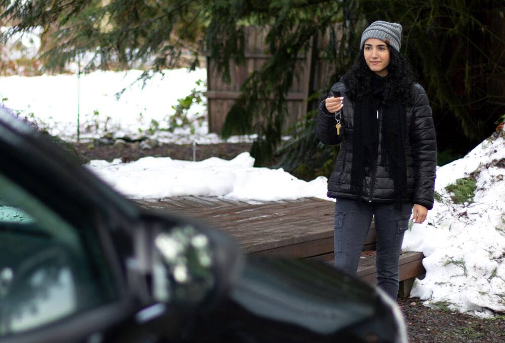Person pointing remote at car
