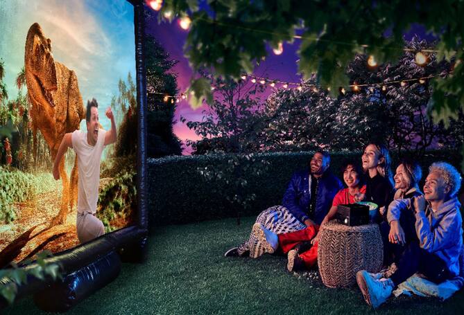 People watching a projector screen outside