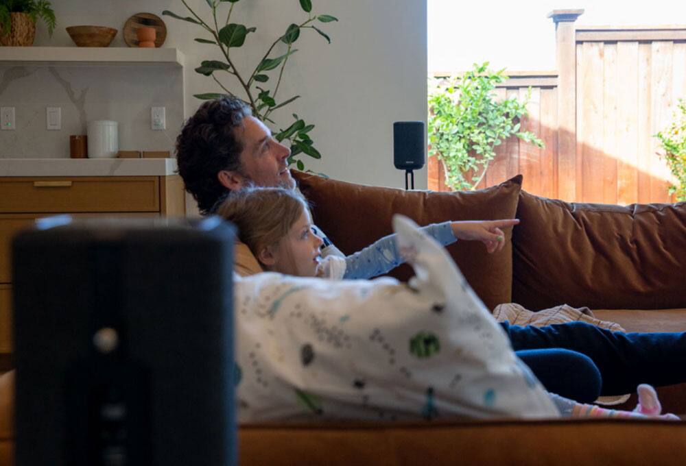 Man and girl in home theater with speakers