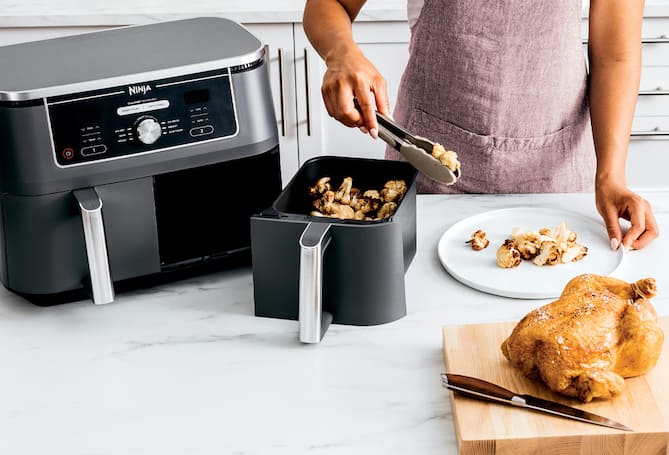 Person taking food out of air fryer