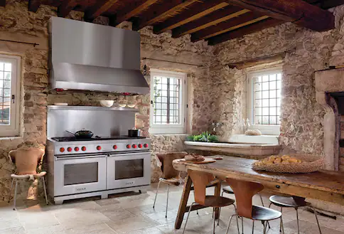 Brick wall kitchen with stainless steel range and hood